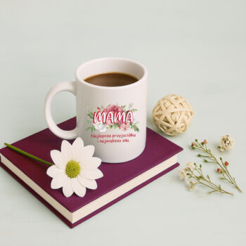 Kubek na książce z kawą i kwiatkiem