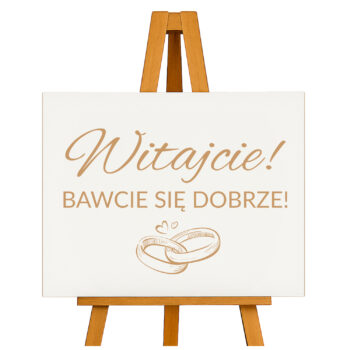 Drewniana tablica z napisem „Witajcie! Bawcie się dobrze!” na sztaludze – widok katalogowy