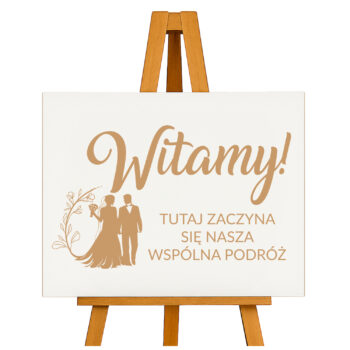 Drewniana tablica weselna z napisem „Witamy! Tutaj zaczyna się nasza wspólna podróż” na sztaludze – widok katalogowy