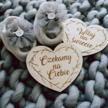 serduszka z napisami: „Witaj na świecie”, „1 miesiąc”, „2 miesiąc” – ułożone na kocyku