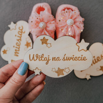 drewniane chmurki z napisami: „1 miesiąc”, „2 miesiąc”, „Czekamy na Ciebie” – aranżacja zdjęciowa