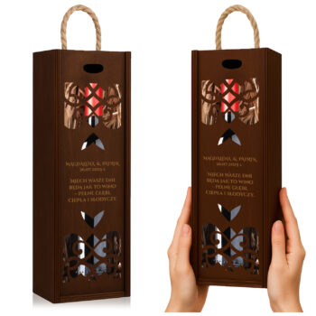 Brązowe pudełko prezentowe na wino z ozdobnym wycięciem i grafiką kwiatów, trzymane w dłoniach