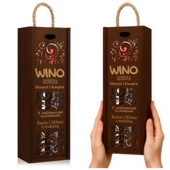 Brązowe pudełko prezentowe na wino z ozdobnym nadrukiem, trzymane w dłoniach