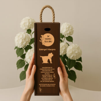 Eleganckie pudełko na wino z motywem psa i dedykacją ślubną, trzymane w dłoniach na tle białych hortensji.