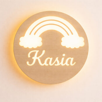Zbliżenie świecącej lampki z tęczą, chmurkami i napisem „Kasia” na jasnej ścianie