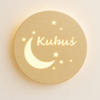 Zbliżenie świecącej lampki z księżycem, gwiazdkami i napisem „Kubuś” na jasnej ścianie.