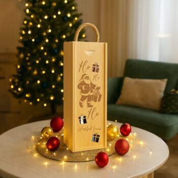 Skrzynka na wino „Ho Ho Ho – Wesołych Świąt” ustawiona przy choince w świątecznej aranżacji.