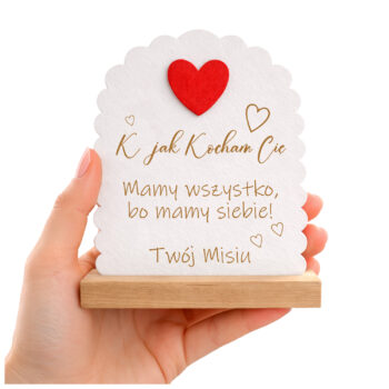 Drewniana statuetka z grawerem i czerwonym sercem – prezent na Walentynki, w dłoni na białym tle.
