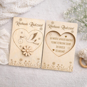 Dwie drewniane kartki do ogłoszenia ciąży dla rodziców i dziadków, ułożone na jasnym tle z delikatnymi kwiatami.